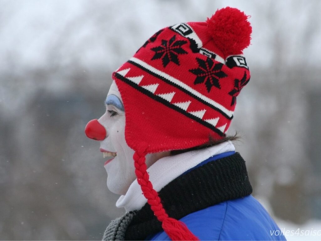 Clown portant une tuque rouge avec des motifs et un nez rouge