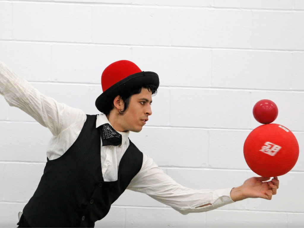 Artiste de crique tenant deux ballons en équilibre l'un sur l'autre