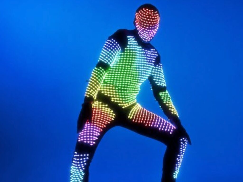 Personnage avec un costume lumineux multicolore qui danse