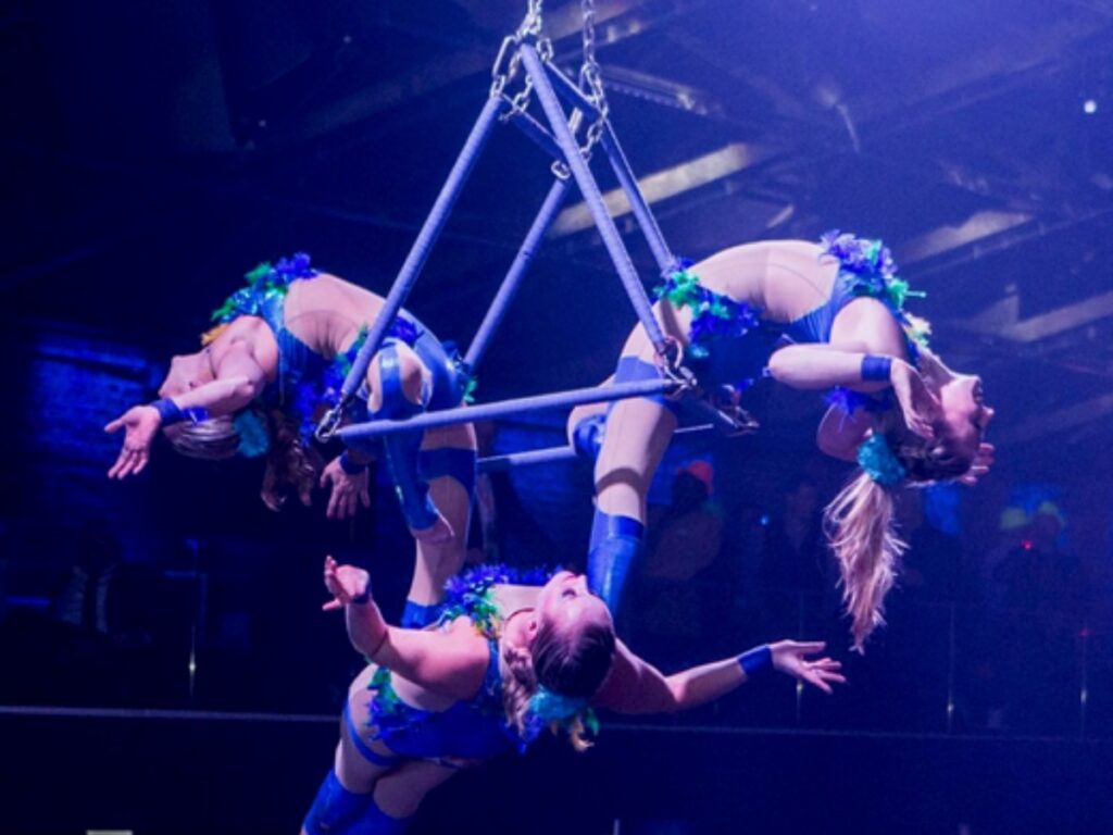 trois trapézistes sur une installation aérienne