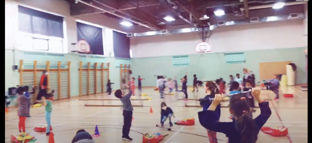 Gymnase avec des enfants pratiquants des ateliers de cirque, jonglerie, magie