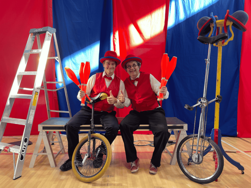 Deux jongleurs devant une scène avec des quilles dans les mains