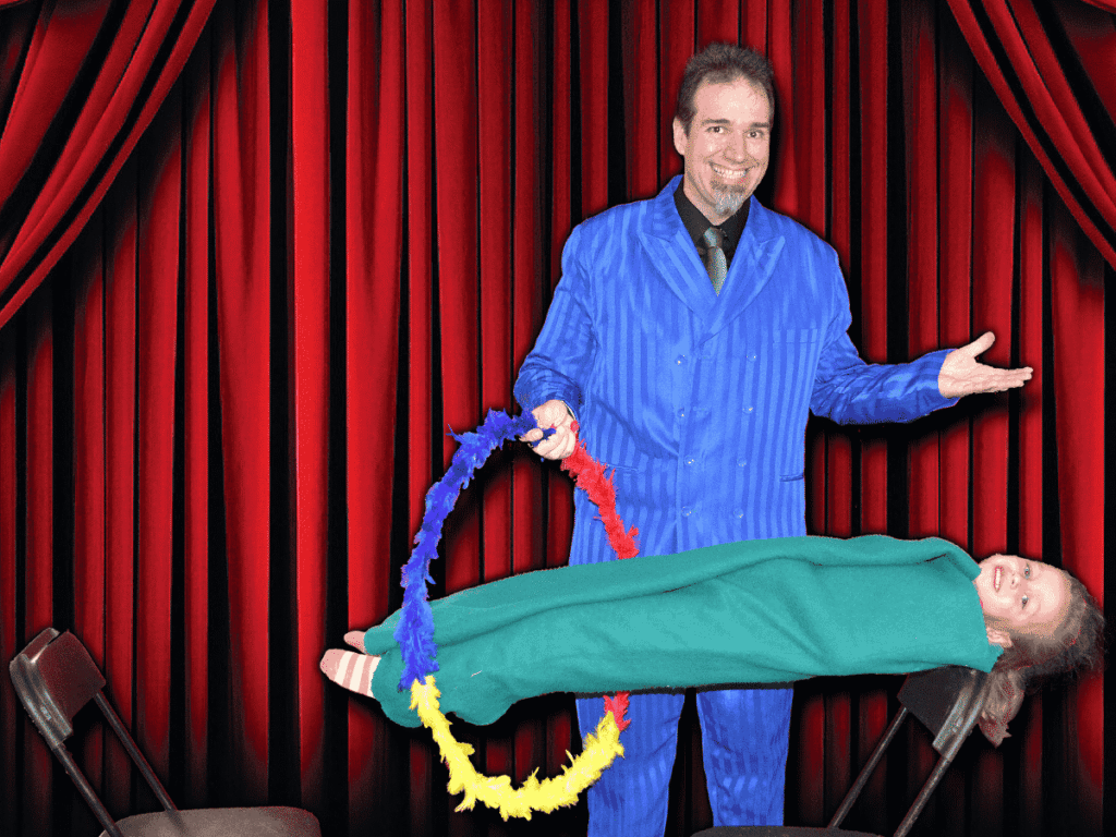 Magicien tenant un cerceau et un enfant en équilibre sur une chaise